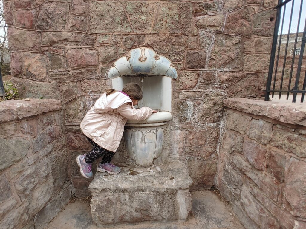 A young girl tasting mineral water at Manitou Springs fountain