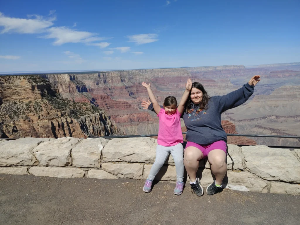 a young girl and woman sitting on the edge of a grand canyon overlook along the Hermit's Rest Route. 