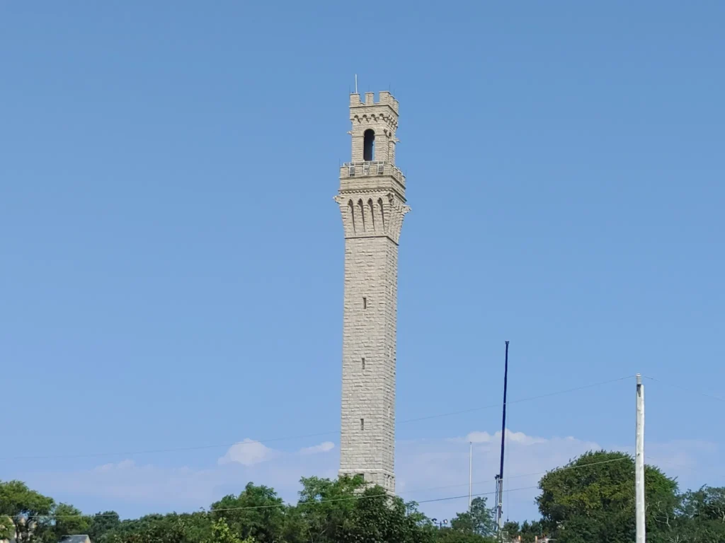 Pilgrim Monument towering over Provincetown under a clear blue sky
