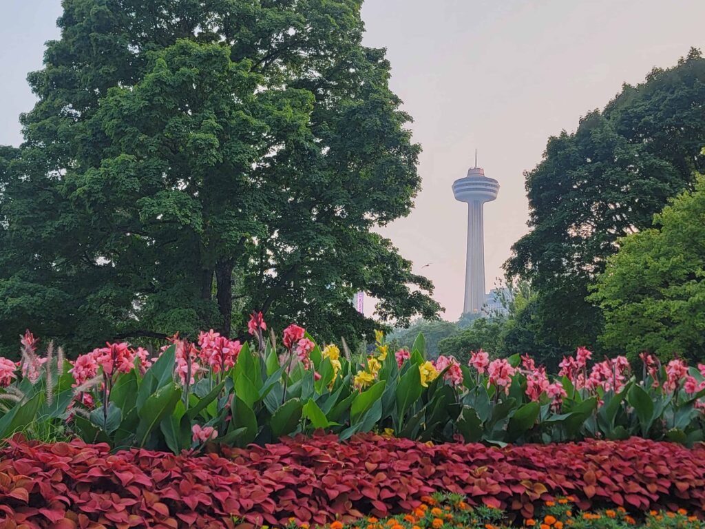 Colorful flower gardens frame the Skylon Tower, a popular Niagara Falls landmark offering panoramic views of the surrounding area.