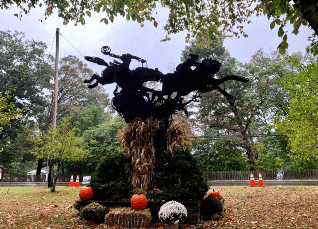 the statue of the headless horseman chasing Ichabod Crane with hay and pumpkins in the foreground