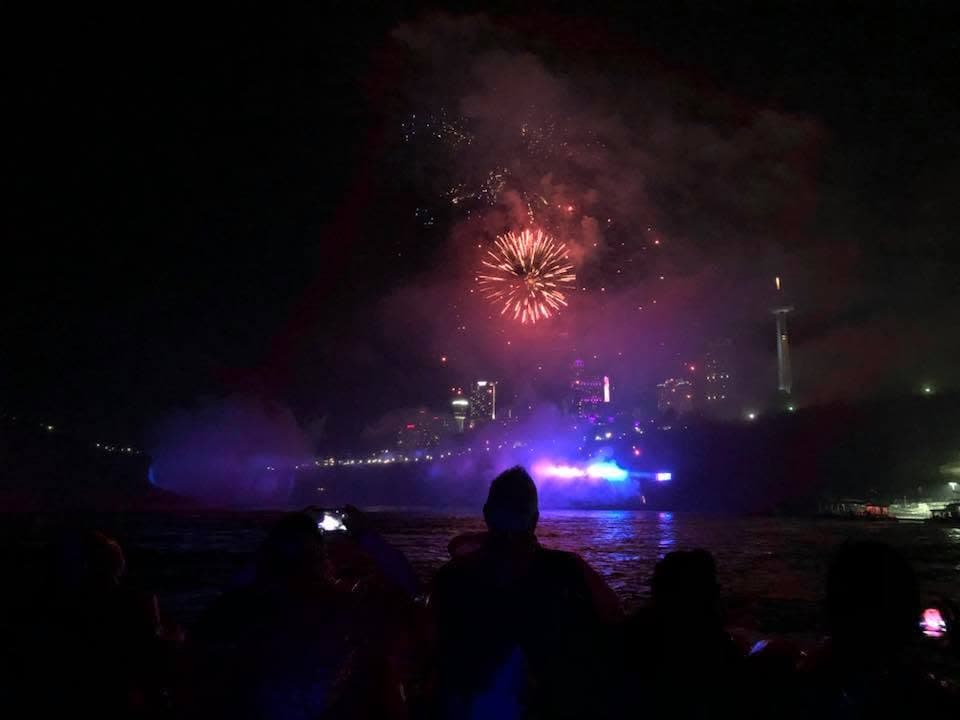 Visitors watch fireworks illuminate Niagara Falls and the night sky during an evening boat cruise., one of the best things to do in Niagara Falls with kids