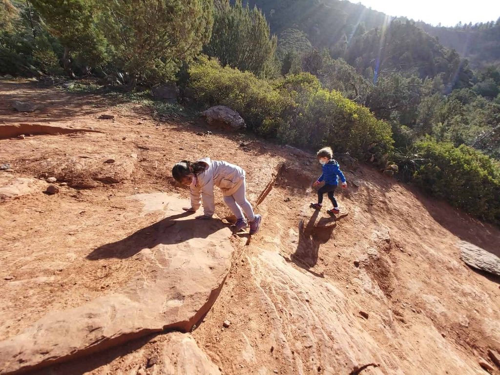 two young children climbing red rocks, one of the best things to do in Sedona with kids 